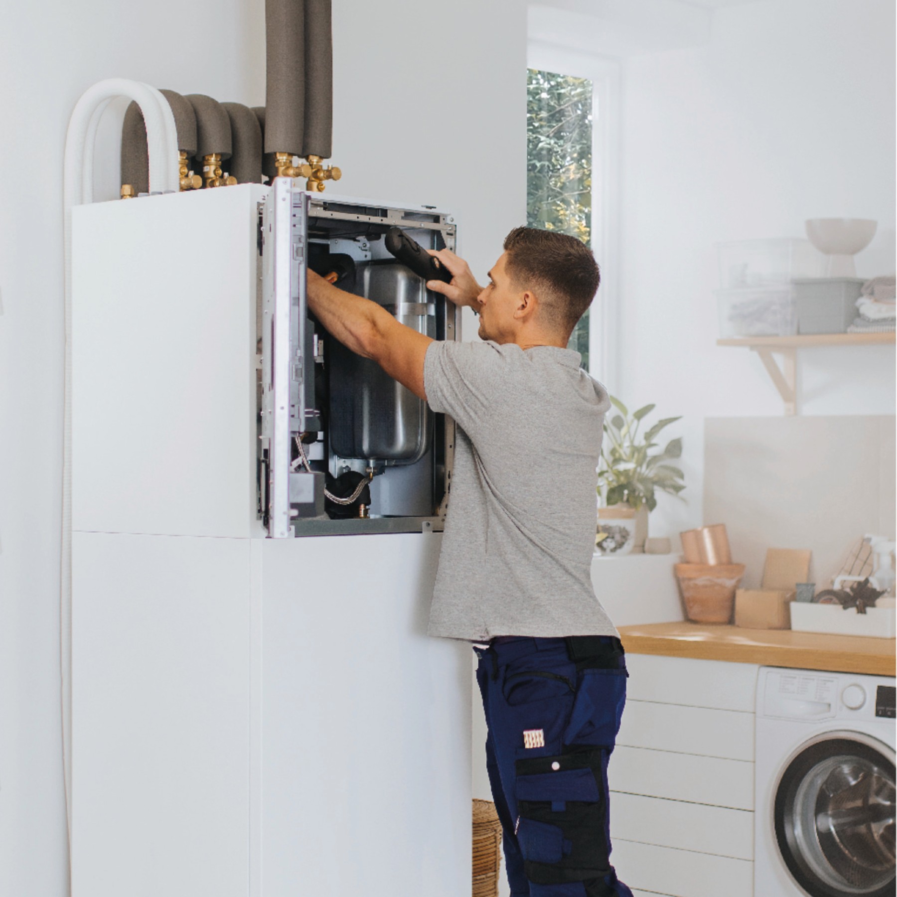 Fachhandwerker arbeitet an der geöffneten Inneneinheit einer Vaillant Wärmepumpe – Herstellerfoto